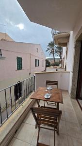 a wooden table and chairs on a balcony at Monolocale in centro con parcheggio privato! in Palau