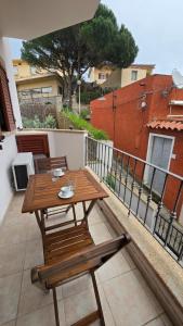 a wooden table and chairs on a balcony at Monolocale in centro con parcheggio privato! in Palau