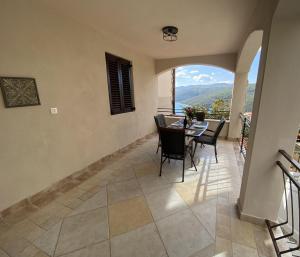 a dining room with a table and chairs on a balcony at Lady M in Rabac - Istrien in Rabac