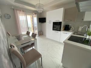 a kitchen with white cabinets and a table and chairs at Lady M in Rabac - Istrien in Rabac +23 photos