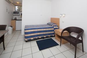 1 dormitorio con 1 cama, 1 mesa y 1 silla en Tally Ho Motor Inn, en Tenterfield