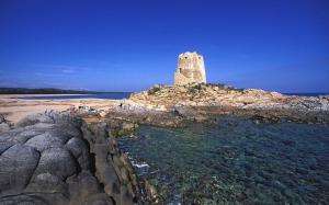 a stone tower on an island in the water at Skyline Terrace in Loceri
