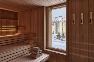 a sauna with a window and a snowy mountain at Hotel Laudinella in St. Moritz