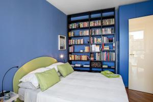 una camera blu con un letto e una libreria con libri di Sull'Acqua del Porto Antico a Genova