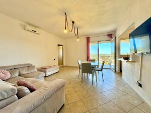 a living room with a couch and a table at Skyline Terrace in Loceri