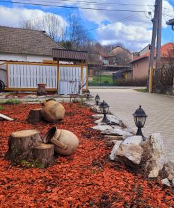a garden with logs and lights on a street at Anna Vendégház Szilvásvárad in Szilvásvárad