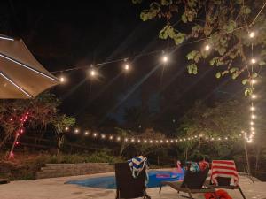 a patio with two chairs and a pool at night at Hilltop retreat - Large pool in Woodlawn