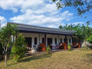 a house with chairs and trees in front of it at Lanta Mother House in Ko Lanta