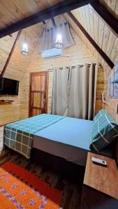 a bedroom with a large bed in a cabin at Chalé da Ilha in Guaraqueçaba