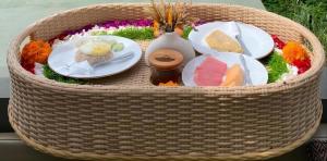 a basket of food with plates and vases on it at Highland Bali in Baturaja