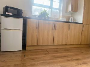 a kitchen with a refrigerator and a microwave at Compact single room A near Heathrow with 24 hour buses to all terminals in Feltham +12 photos
