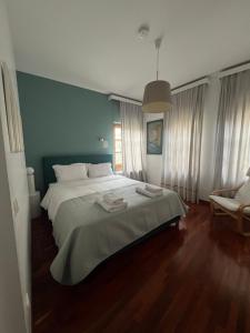 a bedroom with a large bed and a blue wall at Αρχοντικό Λίθος in Kastoria