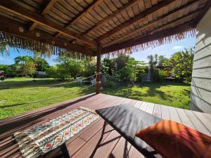 a porch with a hammock on a deck at Rangiroa Tiny House - Tiaré le cocoon in Tiputa