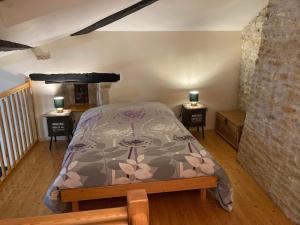 a bedroom with a bed and two tables with lamps on them at La maisonnette de la venelle in Chaunay