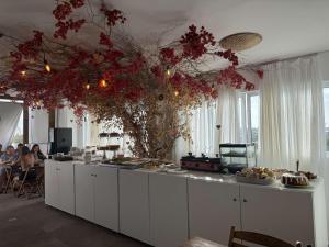 a kitchen with a long counter with a bunch of flowers at Porto Vila by AFT in Porto De Galinhas