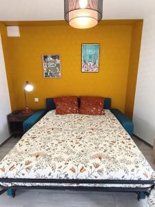 a bed in a room with a yellow wall at Le Nautile - petit déjeuner - 10mn du Parc in Treize-Vents +22 photos