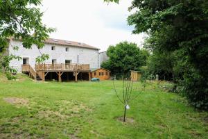 a large white building with a deck in a yard at Le Nautile - petit déjeuner - 10mn du Parc in Treize-Vents