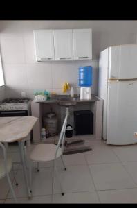 a kitchen with a table and a white refrigerator at Casa na várzea Quarto 1 in Recife