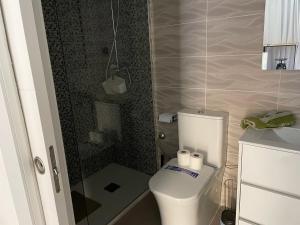 a bathroom with a toilet and a glass shower at Hidden treasure in Playa de las Americas