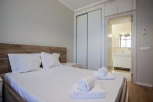 a bedroom with a white bed with towels on it at QUANICE - Relaxing Guest House in Faro in Faro