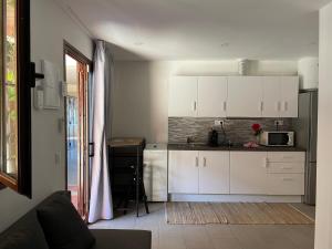 a kitchen with white cabinets and a microwave at Hidden treasure in Playa de las Americas