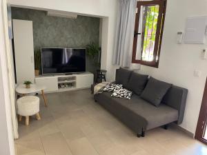 a living room with a couch and a tv at Hidden treasure in Playa de las Americas
