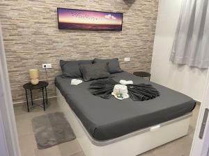 a bed in a room with a wall at Hidden treasure in Playa de las Americas