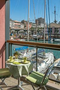 Sull'Acqua del Porto Antico في جينوا: طاولة وكراسي على شرفة مع مارينا