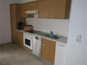 a kitchen with wooden cabinets and a white stove top oven at Ferienhof Windegg in Stockach