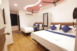 a hotel room with two beds with blue pillows at Tharvi Hotels in Jāmb