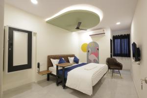 a bedroom with a bed with a painting on it at Tharvi Hotels in Jāmb