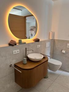 a bathroom with a sink and a mirror and a toilet at Apartment Fidelia in Vandans +14 photos