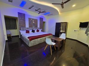 a bedroom with a bed and a table and chairs at Yercaud Misty Haven in Yercaud +16 photos