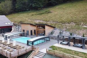 an aerial view of a house with a swimming pool at La Ferme de Rochesson, Jacuzzis & Piscine commune in Rochesson