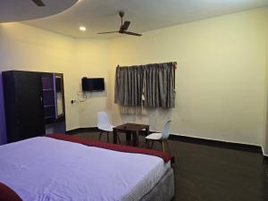 a bedroom with a bed and a table and chairs at Yercaud Misty Haven in Yercaud