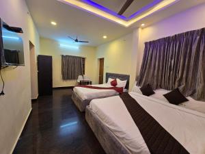 a hotel room with two beds and a tv at Yercaud Misty Haven in Yercaud