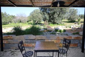 a patio with a table and chairs and a garden at Uma Casa Rural in Santa Bárbara de Nexe