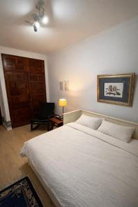 a bedroom with a large white bed and a chair at Double Room near Lisbon & Sintra in Queluz +4 photos