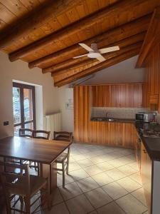 a kitchen with a table and a ceiling fan at Orobie Holiday Apartments in Albosaggia
