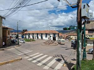 a street in a town with cars and a building at Hospedaje chakana inn in Cusco