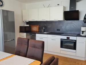 a kitchen with white cabinets and a table and chairs at Ferienwohnung Schabmüller in Kelheim