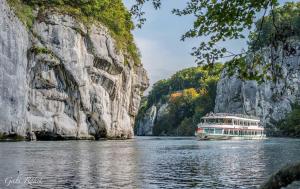 a boat on the water next to a mountain at Ferienwohnung Schabmüller in Kelheim