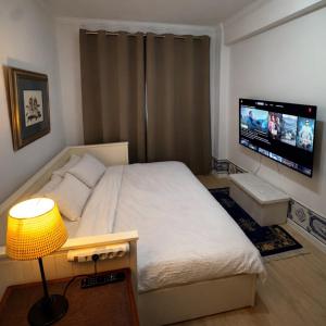 a bedroom with a bed and a flat screen tv at Double Room near Lisbon & Sintra in Queluz