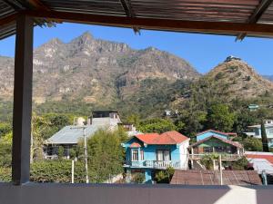 a view of houses and mountains from a window at Hotel Julián Cotuc in San Juan La Laguna