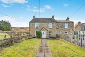 an old brick house with a white door and a fence at 4 Bed in Nenthead oc-c34669 in Nenthead