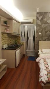 a room with a kitchen and a bed in it at Papilukas Room Kalibata City - Studio Silver in Jakarta
