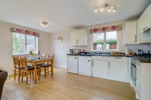 a kitchen with white cabinets and a table and chairs at 2 Bed in Coaley oc-s34729 in Coaley