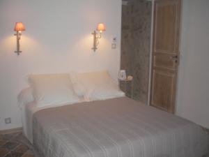 una camera da letto con un letto con due luci sul muro di La Maison de Papé a Combas