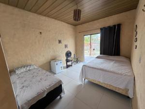 a bedroom with two beds in a room with a window at Vila Macapaz Kitesurf in Luis Correia