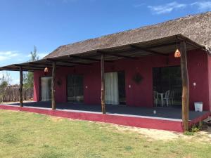 a red building with a thatched roof at Vila Macapaz Kitesurf in Luis Correia